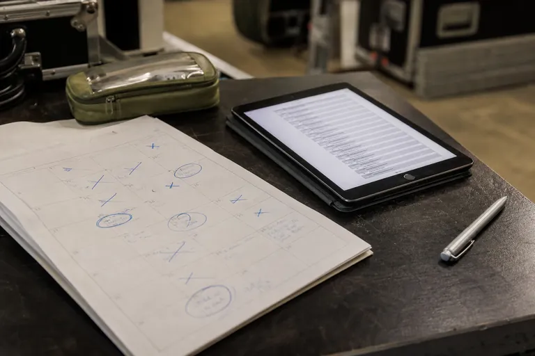 Vereinskalender mit Konzertterminen neben einem Tablet mit digitaler Setliste.