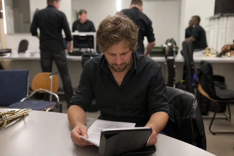 Bandmitglied gleicht eine digitale Setliste mit Notenblättern ab.